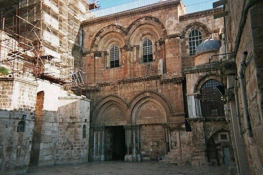 A historic building with arched windows and a dome, surrounded by scaffolding. 5