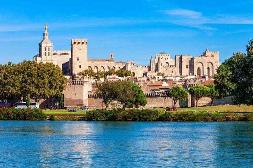Un paisaje urbano histórico con una estructura imponente que recuerda a un castillo, un río y abundante vegetación. 4