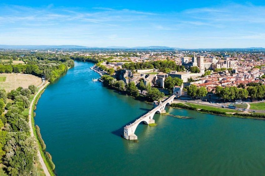 Un río con un puente, un pueblo y una estructura que parece un castillo. 1
