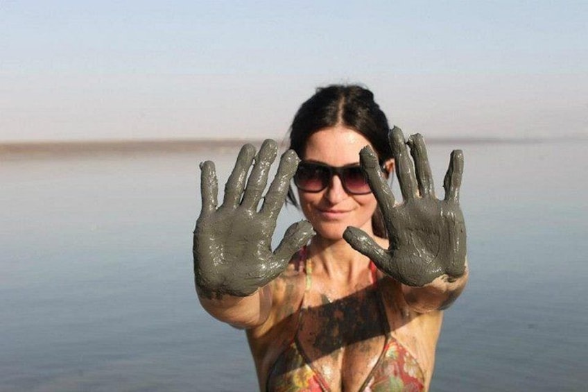 Une personne dont les mains sont couvertes de boue, se tenant dans une étendue d’eau. 3