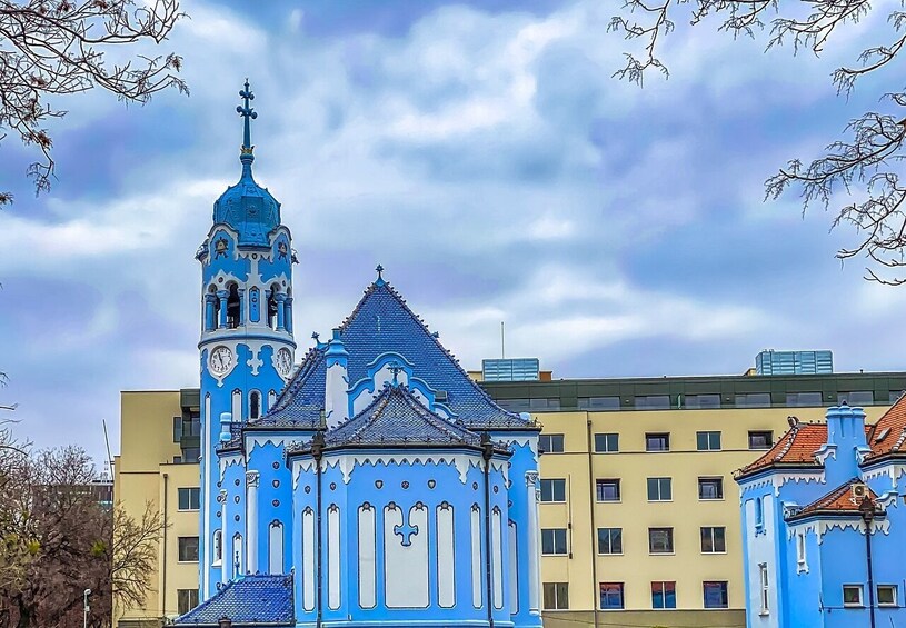 Une église bleue dotée d’un clocher et d’un plus petit beffroi. 1