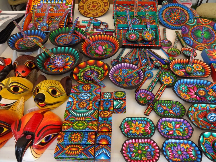 A variety of colorful, intricately painted ceramic bowls and masks. 2