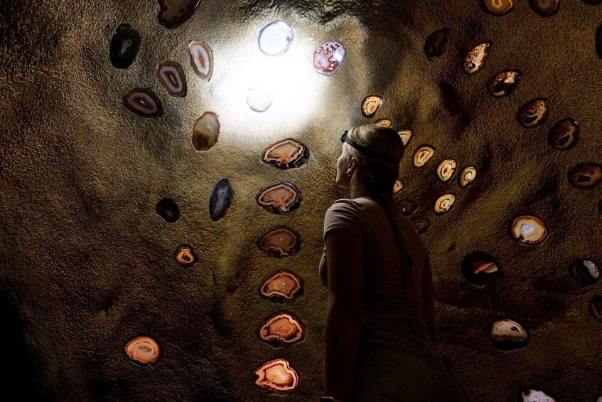 A person observing a collection of polished stones in a cave. 1