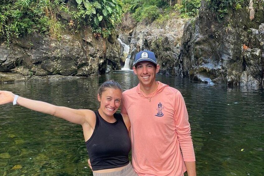 Due persone si fanno un selfie davanti a una cascata in un ambiente naturale. 3