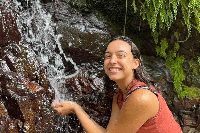 A person near a waterfall with water cascading over rocks. 4