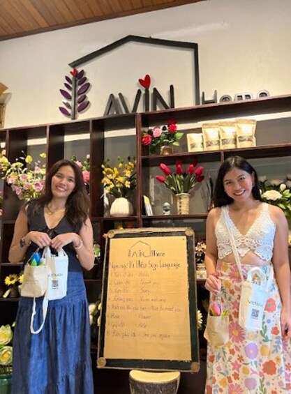 Dos mujeres en una tienda con arreglos florales y una pizarra con el menú. 5