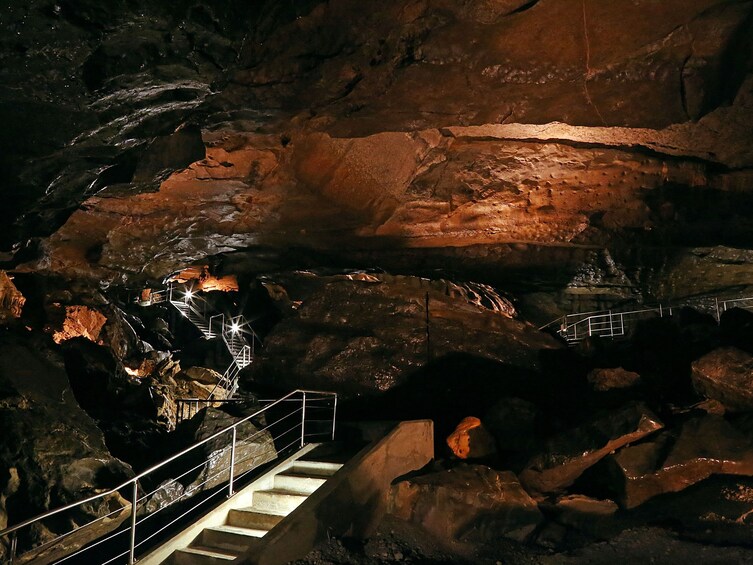 A cave with natural rock formations and a metal staircase. 2