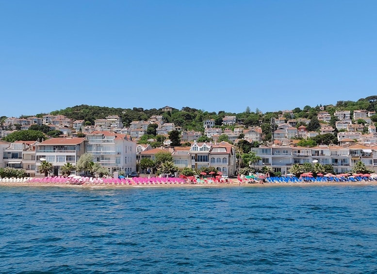 A coastal town with buildings, a beach, and umbrellas. 2