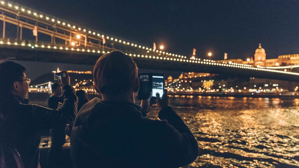 People taking photos of a bridge at night. 4
