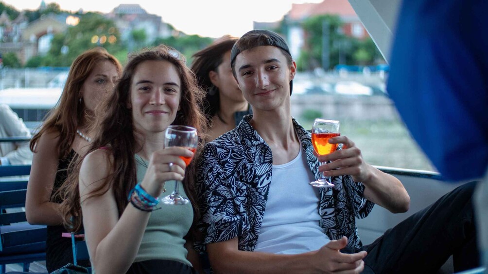 Three people on a boat, holding glasses of a red beverage. 2