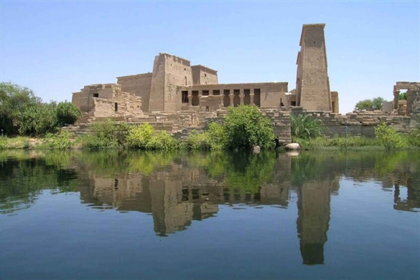 Ancient ruins with a large pyramid and a temple reflecting in a calm body of water. 3