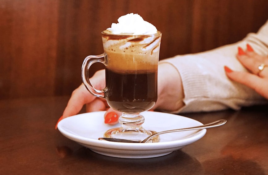 A cup of coffee with whipped cream on a saucer. 3