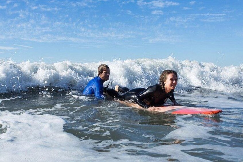 Two people on surfboards in the ocean with waves. 3