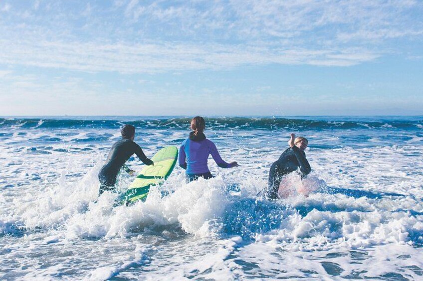 Three people surfing in the ocean. 1