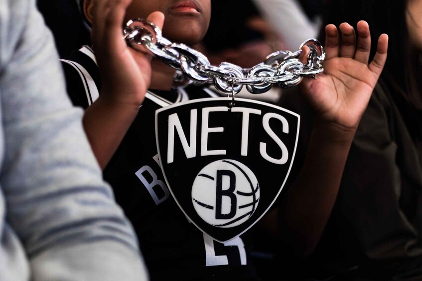 A person wearing a black jersey with a white logo and text. 4