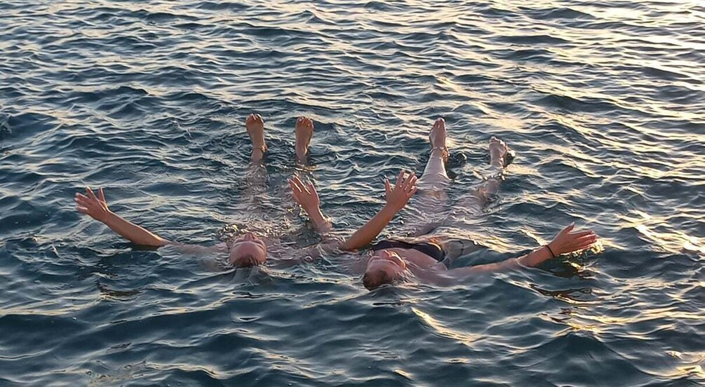 A person floating on water with arms spread out. 3