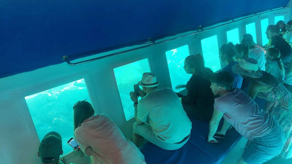 People on a boat with large windows, looking at the ocean. 5