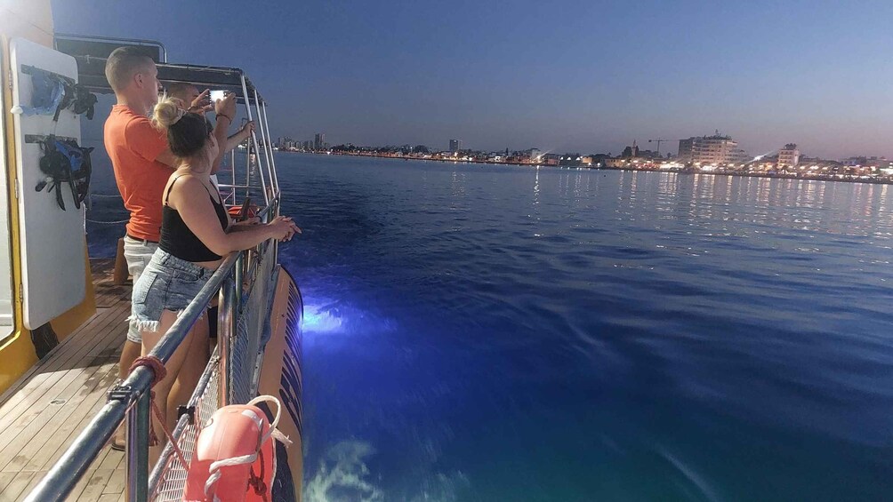 People on a boat with a city skyline in the background. 2
