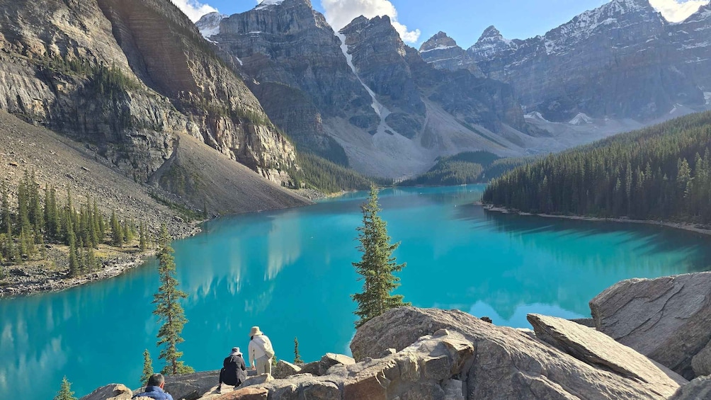 A turquoise lake surrounded by mountains and trees. 3