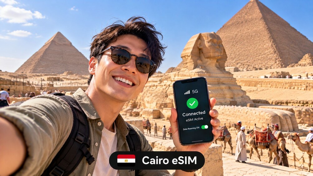 Eine Person hält ein Smartphone mit 5G-Verbindung vor der Großen Pyramide von Giza. 1