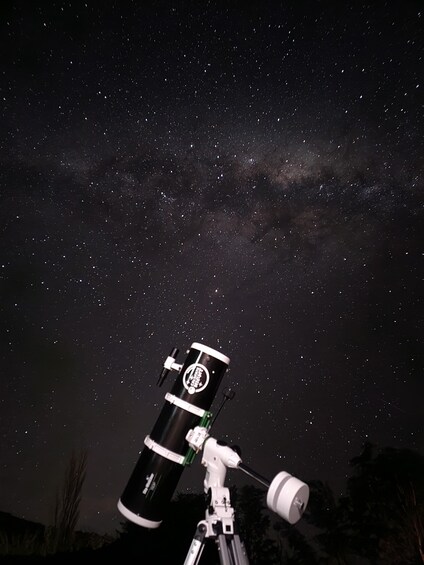A telescope against a starry night sky. 5