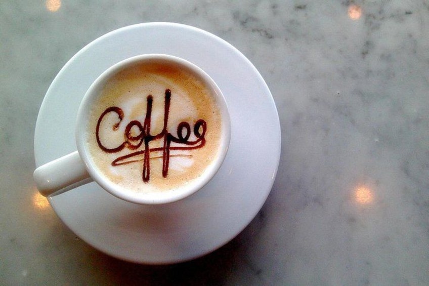 Une tasse de café sur laquelle est écrit le mot « Café » à la surface de la mousse. 3