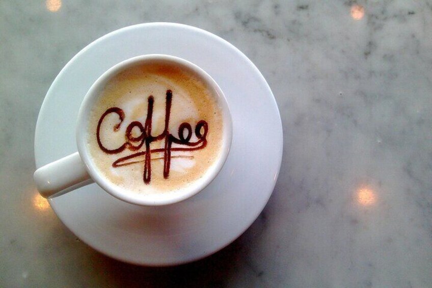 Una tazza di caffè con la scritta 'Coffee' in cioccolato sulla schiuma. 3