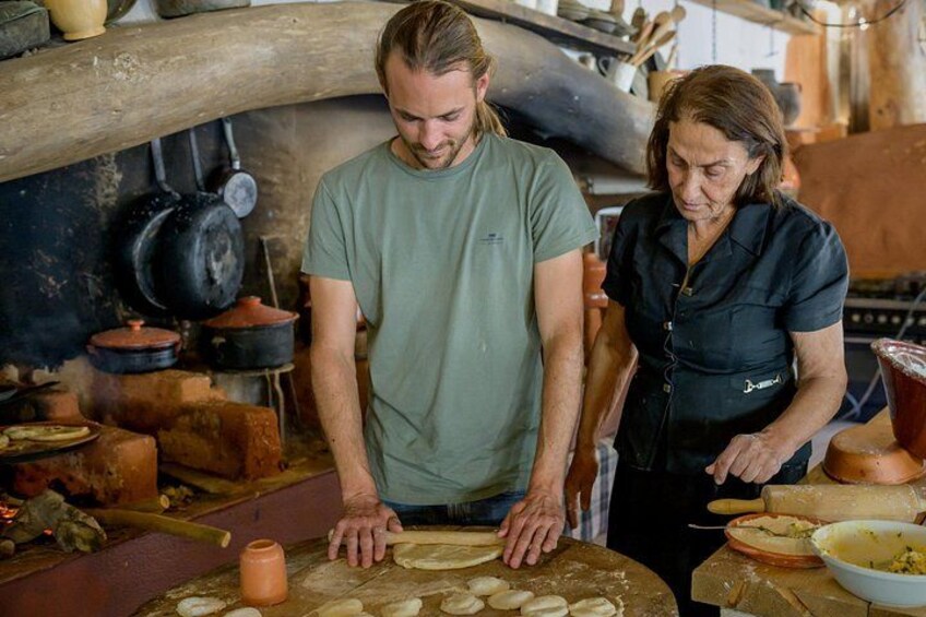 Two people in a rustic kitchen preparing food. 4