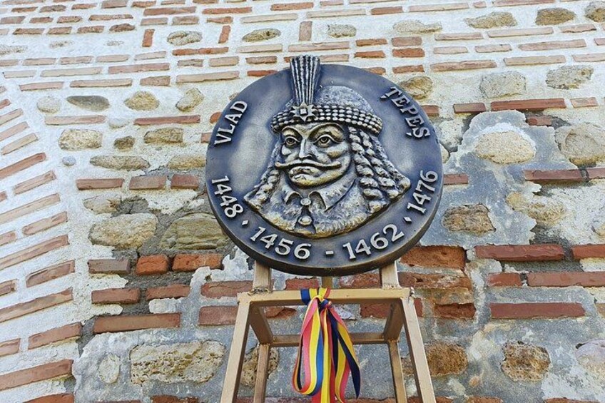Una placa histórica con el retrato de un hombre y las fechas 1448-1462-1476. 5