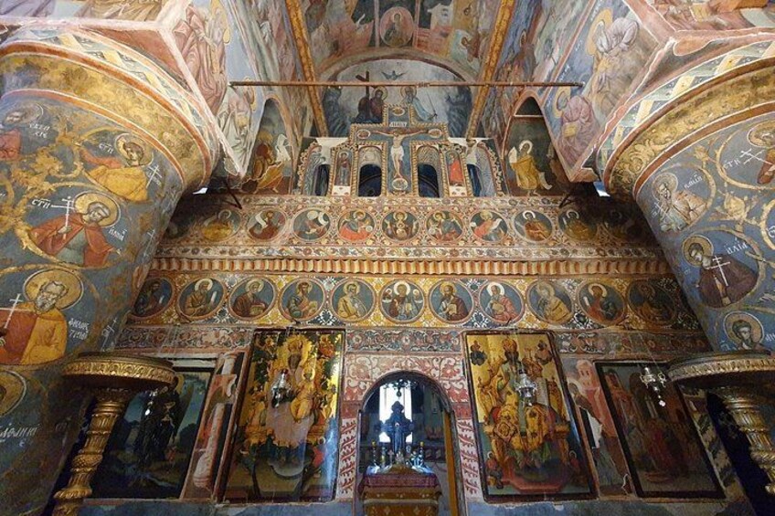 Un interior ricamente decorado con frescos ornamentales e iconografía religiosa. 4
