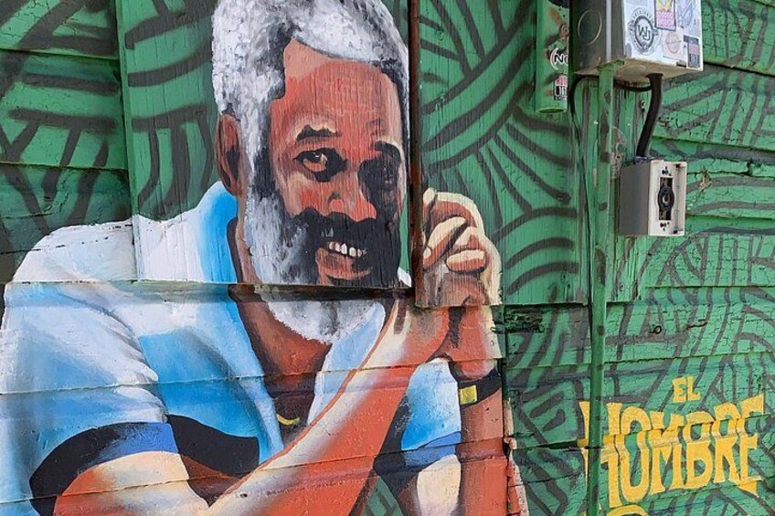 A mural on a green wall with a hand gesture and the text 'EL JUMBRE'. 2