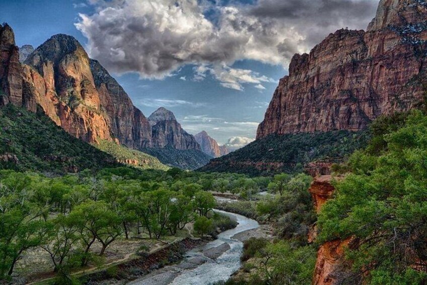 Un río serpentea por un cañón con acantilados de roca roja y vegetación verde. 2
