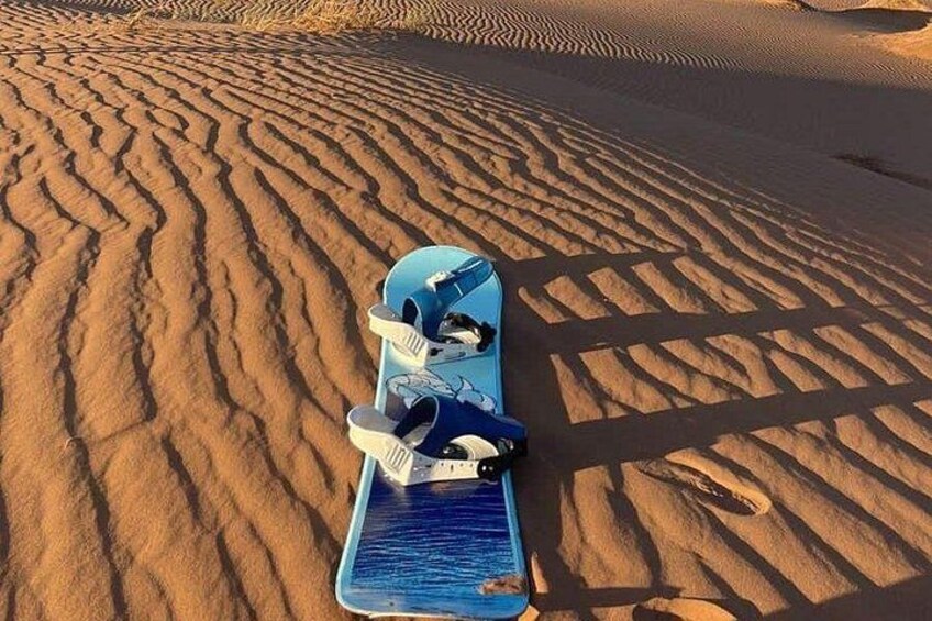 Un monopatín azul sobre una superficie arenosa con marcas de neumáticos. 2
