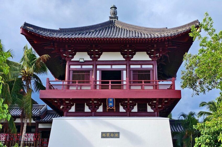 A traditional Japanese pagoda with a red roof and white walls, surrounded by greenery. 3