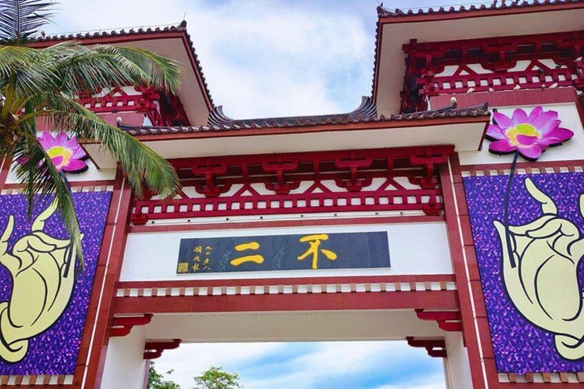 A traditional gate with Chinese characters, a palm tree, and decorative flowers. 5