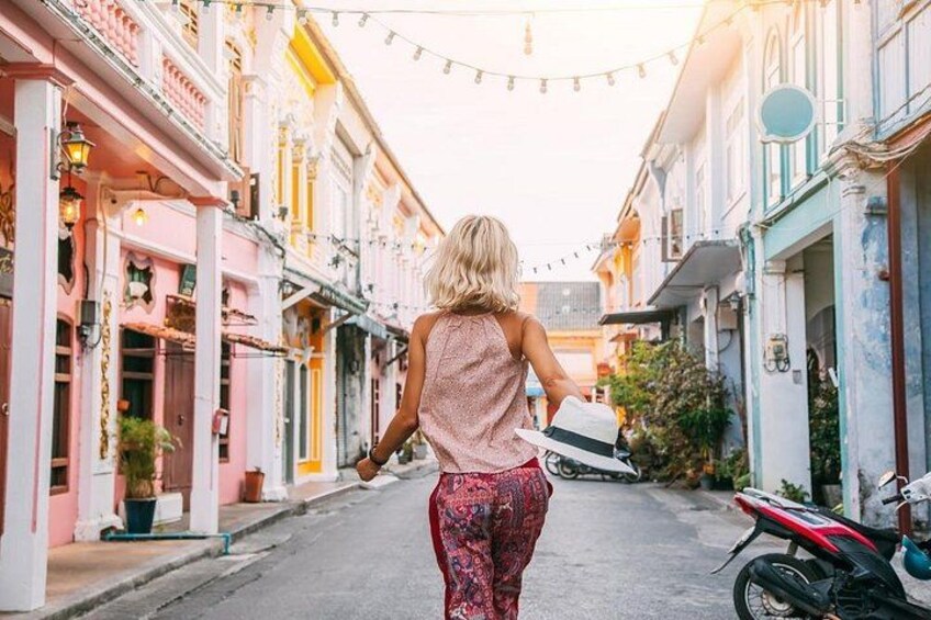 A woman walking down a narrow street lined with colorful buildings. 5