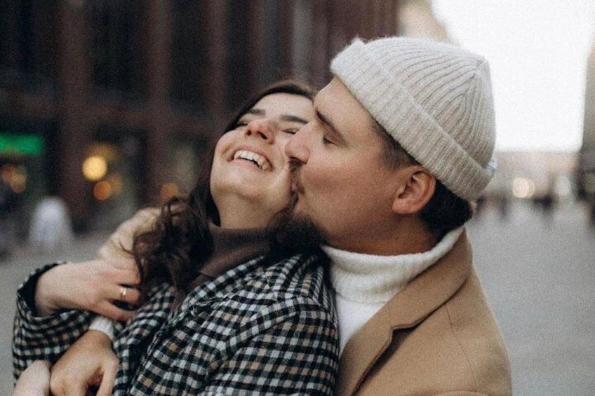 A couple embracing in an urban setting with buildings in the background. 5