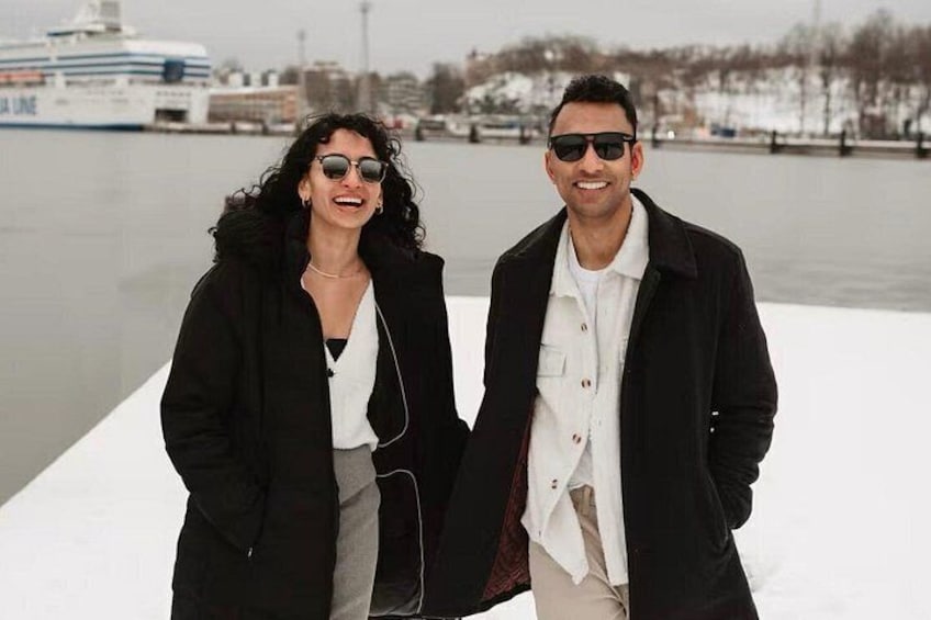 Two people standing on a dock with a ship in the background. 3