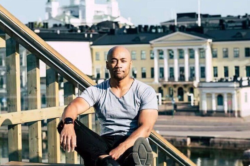 A person sitting on a railing with a cityscape in the background. 4