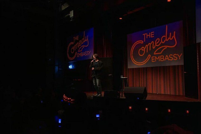 Un escenario con un cartel que dice 'The Comedy Embassy'. 4