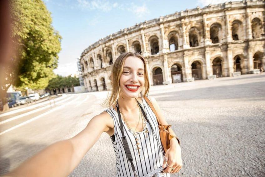 A person taking a selfie with the Colosseum in the background. 1