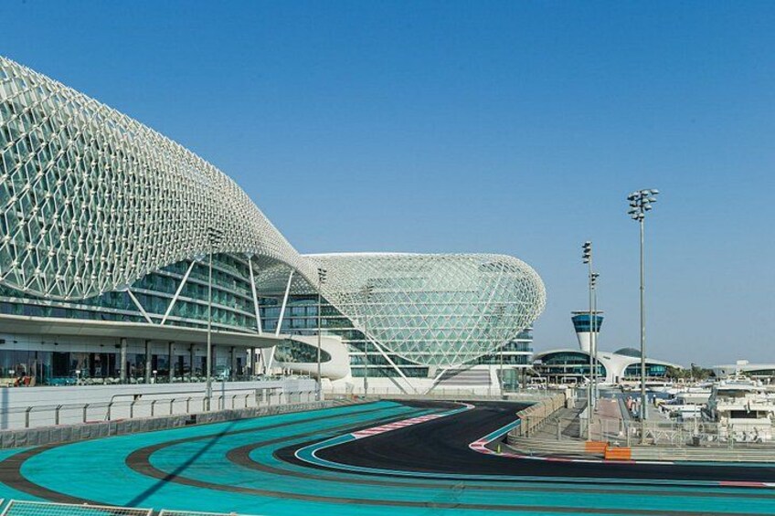 Un estadio moderno con una estructura de techo curva y una pista para eventos de carreras. 2