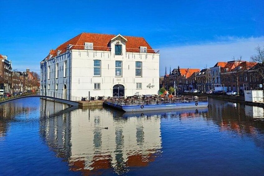 Ein weißes Gebäude mit rotem Dach, ein Kanal und ein kleines Boot. 4