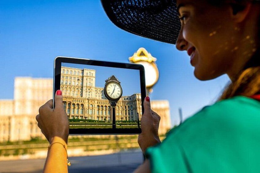 Una persona sosteniendo una tableta que muestra una torre del reloj. 5
