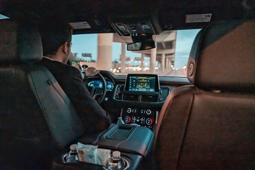 A car interior with leather seats, a digital dashboard, and a cup holder. 4