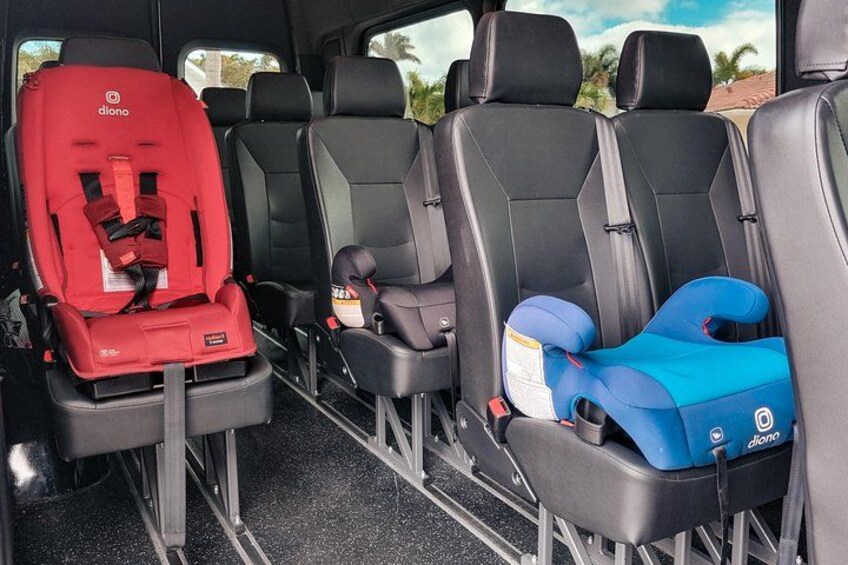 A vehicle interior with black seats and two child car seats, one red and one blue. 5