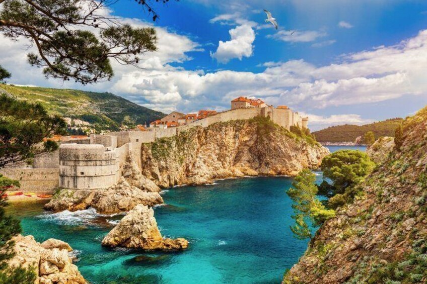 Une ville côtière dotée d’un château historique perché sur une falaise, bordée d’eaux d’un bleu limpide et d’un paysage rocheux. 5