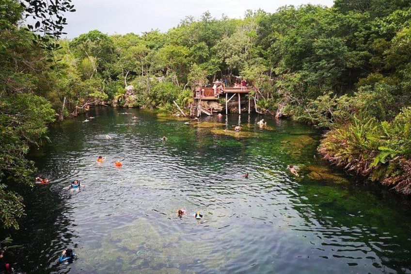 Un río con gente nadando y un puente de madera. 2