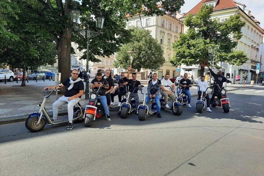 A group of people riding electric scooters on a city street. 1