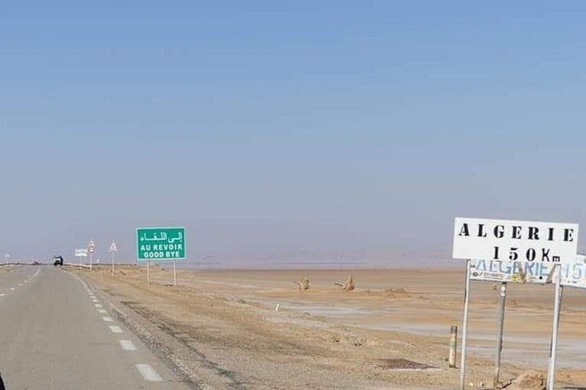 A road with desert scenery, road signs, and a clear sky. 2